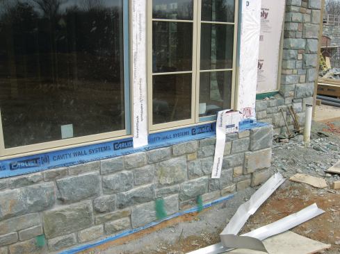 It's important to run the through-wall flashing long enough so that the jamb flashing, as well as the sill pan, lap over it. This includes the jamb flashing between windows.