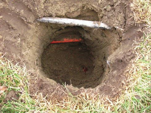 Before digging footing holes, call 811, your local utility locator. It will find and mark utility lines, but dig carefully; this service doesn’t typically locate sprinkler lines, and here it missed a telecom cable conduit, too. 