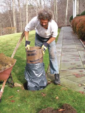 Garbage-bag footing bases are useful in wet conditions and when your footings are wider than concrete tubes but smaller than prefabricated wide-base forms. The author digs a 12-inch-diameter hole about two-thirds of the footing depth, then widens the last third of the hole to the calculated size. After duct-taping a heavy-duty garbage bag to a footing tube cut 6 inches longer than two-thirds of the depth, he pokes rebar horizontally through the form 6 inches from the top to suspend the form in the hole. Finally, he pours concrete in the bottom third—the bag—then backfills the space between the hole and the form before filling the form to the top with concrete. 