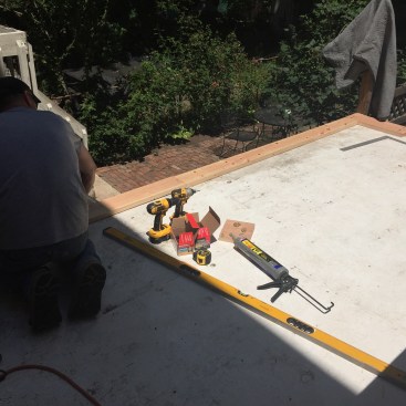 Working on top of the temporary roofing membrane, project manager Danny DoCouto began by installing the first of four layers of 2x10 SPF around the perimeter of the roof, to create a curb.