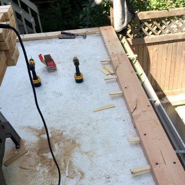 Because the curb establishes the final elevation for the rooftop deck, great care was taken to shim the second 2x10 layer so that it would be absolutely flat and level in every direction. 4 1/2-inch-long structural screws were used to fasten the 2x10 layers to the roof framing and to each other.