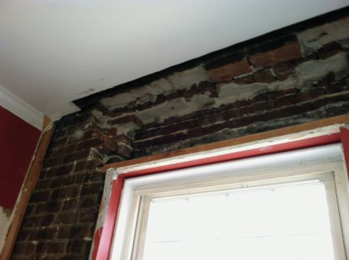 The inner and middle wythes of brick were removed from above the rear window.