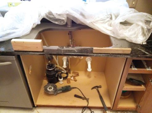 Hot-melt gluing blocks to the sink shoulders helps to keep the granite from falling apart while the rod is being removed.