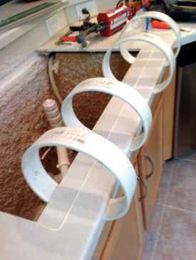 Dani Clamps hold a solid-surface repair together during glue-up. For stone, the author wraps one clamp around another and uses more clamps. 