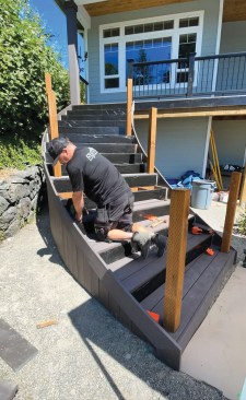 I was able to cold-bend the fascia boards in place. While the inside fascia measured less than 20 feet and thus could be done with a single board, the outside fascia measured more than 20 feet and required a splice joint. This reflects the unequal pitch of the inside—33 degrees—and outside—26 degrees—stringers, which had to be accounted for when fabricating the railing. Neither the left nor the right sides of the 6-foot-wide treads are square, but had to be custom cut to different angles to fit the curved fascia. I used a cutoff as a template to make the cut on one end, then find the length and mark the cut on the other end. After installing the two full-width treads, I used a track saw to cut the inner pie-shaped tread. Before installing the first tread, I had to install the riser first in order to have access to the back of the riser for wiring the riser lights.