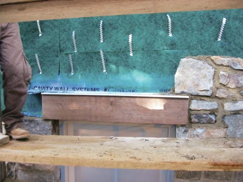 The thicker material stands up to abrasion from masonry and tends to come in wider widths, so we can get a good lap behind the housewrap and still bring the flashing all the way out to the face of the brick. This last point is important because it prevents water from soaking back into the masonry below the flashing and finding its way into the framing. There are purpose-made flashing materials with metal drip edges, but they are expensive, difficult to work with, and aren't stocked in our area. On some jobs, we have fabricated stainless steel drips along the outer visible edge.