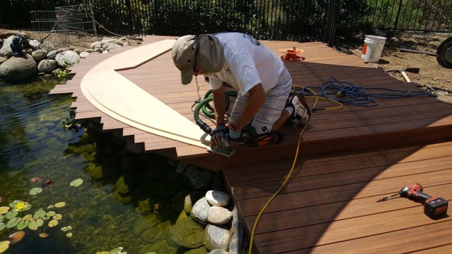 The upper template guides the base of the saw as the author trims the decking to the curve.