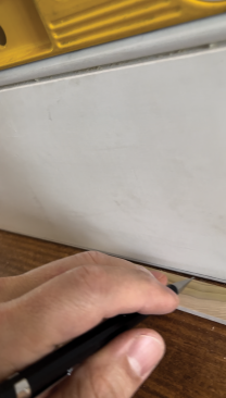 By running a pencil along the scrap and marking the baseboard, you can see what needs to be removed.