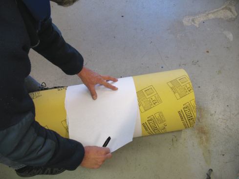 I tape two or three full pages of newsprint end-to-end to make an elongated sheet, then wrap the sheet around the footing form, matching the edges of the sheet as they meet around the cylinder