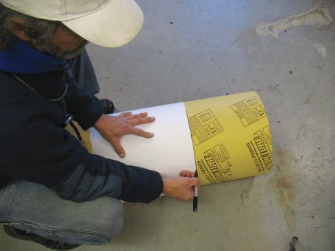 After I tape the end of the newsprint to itself, I slide one edge of the newsprint to the cut point and mark my straight line along the edge of the newsprint.
