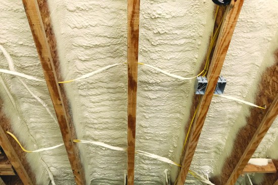 Closed-cell spray foam defines the thermal boundary of the first occupied floor.