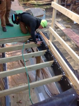 To protect the rim joist, the author makes scuppers out of the scalloped pieces that were cut from the membrane.