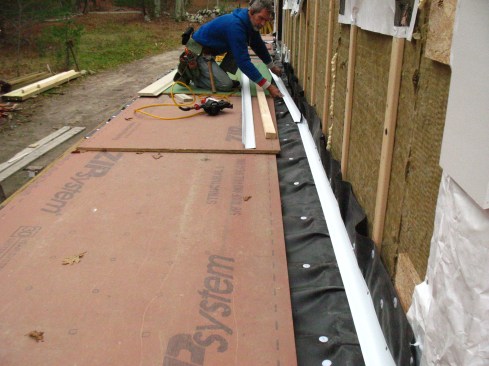 Aluminum flashing covers the joint where the membrane turns up the wall.