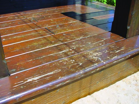 The film-forming finish on this white-cedar decking and PT rim joist is starting to fail.
