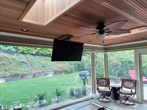 For a basic TV installation on flat and pitched ceilings, the author uses a motorized flip-down mount. On a flat ceiling, the mount can be fitted with a swivel bracket that allows the viewing angle to be adjusted