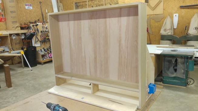 Sometimes an insulated flue runs behind the TV, so when building a recessed TV cabinet, the author will jog around the flue pipe and add fireproof rigid insulation about 2 inches thick for extra insurance.