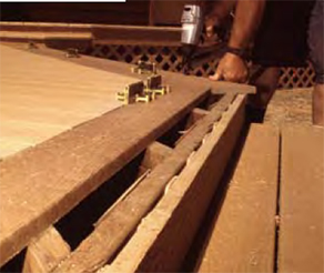 When the fascia was removed, the rim collapsed. Here, on a pressure-treated frame, the author installs composite decking that will completely cover the fascia and rim, avoiding this potential collection zone. The lattice separating the fascia and rim joist will also help to drain away water.