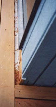It’s common practice to bring an L-shaped flashing down the wall and kick it out over the ledger, the resulting pocket can collect debris.