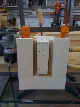 To cut the tenons, the author screwed a plywood pattern to the ends of the perimeter beams. He also clamped a U-shaped jig to the beam to help support the base of the router while making the cuts.