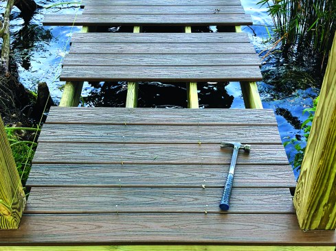 The crew dry-lays the decking to check the layout, spacing the deck boards with 16d nails to make sure water will drain off the dock quickly.