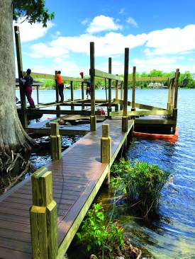 When plans include a boathouse or other roofed structure, the crew installs longer pilings to support the framing.