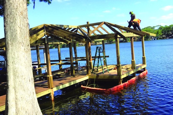 When the crew is working over water, care must be taken to collect offcuts. The orange turbidity curtain is a requirement for containing construction debris.