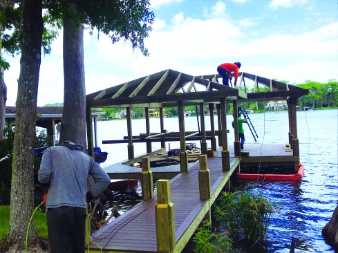 To provide visual interest to the boathouse ceiling, the crew installs grooved T1-11 5⁄8-inch sheathing, with the grooved side facing down.