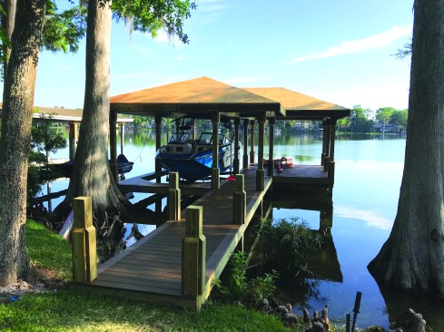 Before the roofing subcontractor arrives to finish off the project, the crew installs a second layer of 1/2-inch plywood sheathing, which strengthens the roof deck and prevents nails from popping through the grooved T1-11 ceiling.