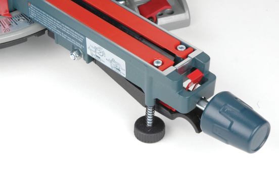 When you’re using some of these sliders on a bench top instead of on a saw stand, an adjustable-height foot under the blade channel lends support if needed. The Bosch (shown here) and both Makita saws have this feature. The small red tab above the locking knob clips over the edge of the blade channel to bypass the miter stops. This feature is exclusive to Bosch.