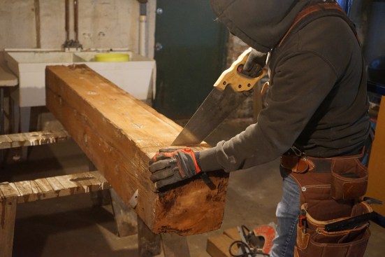 He then finishes the cut with a handsaw.