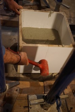 Tapping the form with a dead-blow mallet settles the concrete and helps eliminate voids.