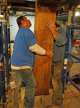 The crew slides the cut post into position.