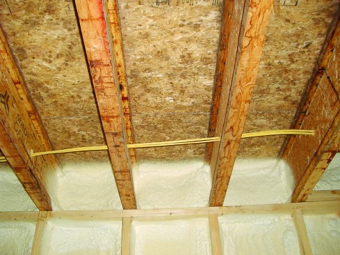 Closed-cell foam applied here provides a good air-seal. Even if you don’t insulate the walls with it (as shown here), hitting the rim-joist area only with foam can be a cost-effective way to air-seal this difficult area.