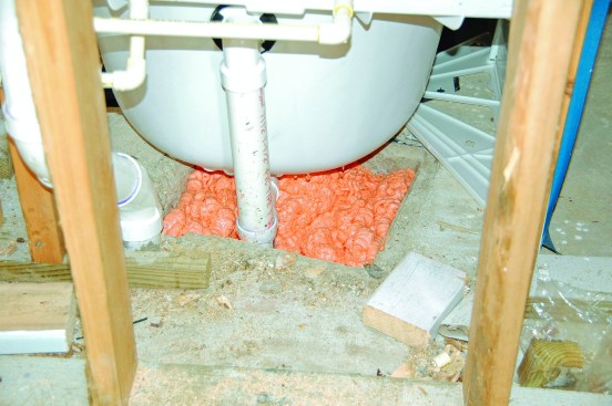 The open area in a first-floor slab that is formed-out to accommodate the drain trap also needs to be sealed. Foam sealant, laboriously installed, can work, but spray-foam insulation might be more efficient to install.