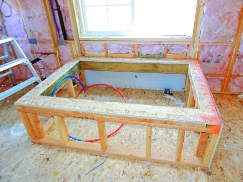 The exterior wall behind a tub or tub platform should be sealed with drywall or sheathing. (Heavy cardboard sheathing, such as Thermoply, works well for this.)