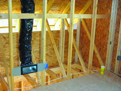 Because this is an attic truss, there is no bottom wall plate at the edge of the floor deck. Additional blocking between the trusses is needed to provide a surface to seal to.