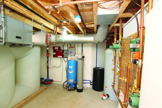 Under the floor, a fan draws outdoor air into a duct and passes it over a heating coil before directing it up into the home’s living space.