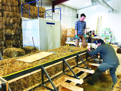 In the shop, panels are assembled in a steel frame and packed with straw bales.