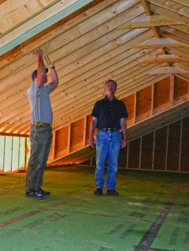 The stick-framed-attic volume is reserved for blown cellulose insulation, with no storage or equipment; here, the architect and builder discuss the ventilation strategy while they still have access to the space.