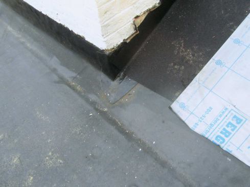 At the roof transition shown in this photo, roofers had installed peel-and-stick over the EPDM lap. They had the right idea, but the peel-and-stick they used was rubberized asphalt, which reacts with EPDM. They also didn't overlap the two membranes enough, so it wouldn't have been long before a significant leak developed along the entire length of the overlap.