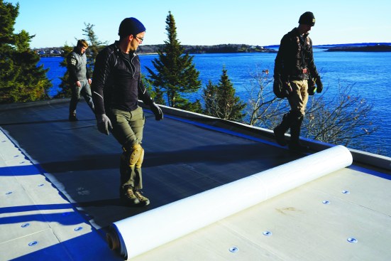 The crew rolls out the EPDM and gives it a half hour to relax.