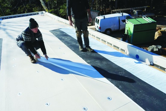 The backing plastic is pulled off the EPDM where it lies on the substrate.