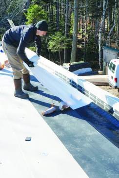 The backing plastic is pulled off the other edge of the membrane.