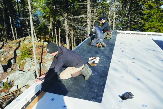 That edge is carefully rolled up onto and over the parapet.