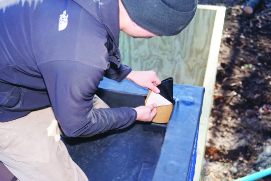 Crew member Zack Payne applied flexible uncured EPDM flashing over a corner joint.