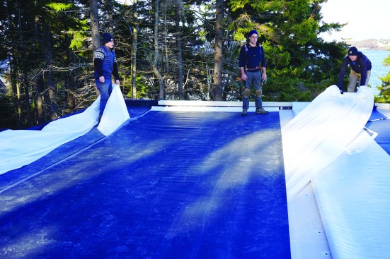 The crew pulled the backing plastic away from a full-width section of EPDM.
