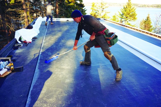 The author used a push broom to press the roofing into place, securing a good bond with the substrate.