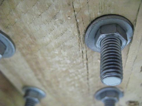 When post kits were installed with bolts and washers rather than with a reinforcing base plate, the washers and nuts began to pull through the blocking long before test loads on the post reached 500 lb.
