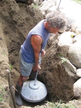 After inserting the galvanized connecting rod, the author lowers the 80-pound base section into position.