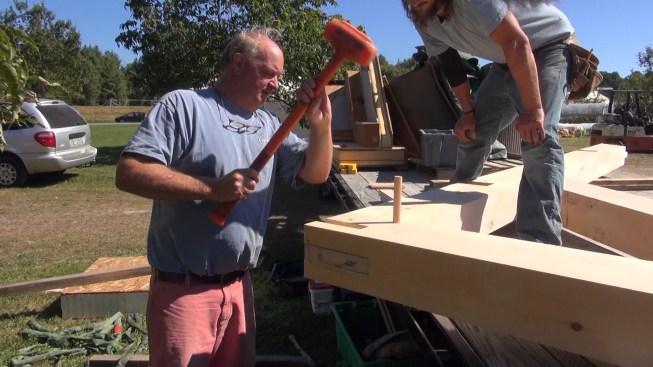 Richard Krouse pounds home a peg at the rafter peak joint.